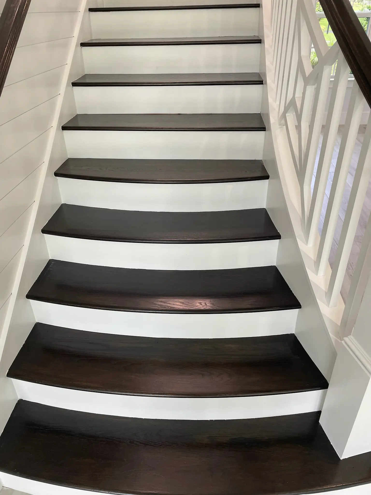 Freshly painted white stair risers with dark stained wood treads and white shiplap wall, interior painting in Wellington, FL